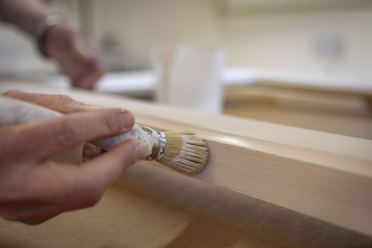 Detail shot of Lucy painting the frame